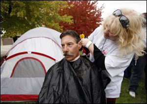 Tim Melanson gets a trim from volunteer Kathy Coykendall. He says he was passing through and wound up at the event.
