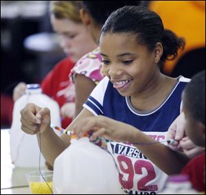 Slug: NBRN music13p Date:  11/04/2008        The Blade/Andy Morrison       Location:   Monroe  Caption: Jasmine Hutchins, 12, has fun as she and other children make shekeres, a Nigerian instrument, as part of Musical Instruments Around the World program at L.S. Navarre Library Branch in Monroe, Wednesday, 11/05/2008. Summary: