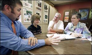 Math teacher Garrett Barga, left, meets to discuss the progress of seventh grader Jimmy Spychala, 12, with parents Jim and Donna Spychala during the parent-teacher conferences at Gateway Middle School in Maumee. Students, usually left out of conferences, are able to participate at Gateway.