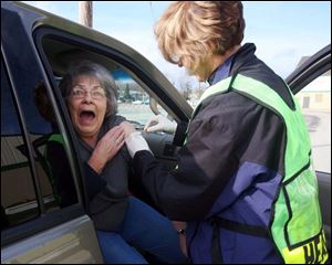 ROV flushot14p 2  Lisa Dutton/ The Toledo Blade   MaumeeOH 11/13/2008 left--Rose Hall of Holland,OH.reacts to getting a flu shot from Lucas County Health Department employee Mary Sheehy (cq) during the drive up flu clinic at Lucas County Recreation Center, 2901 Key St., Maumee