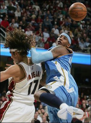 The Cavaliers  Anderson Varejao gets tangled up with Carmelo
Anthony while battling for a rebound last night in Cleveland.
