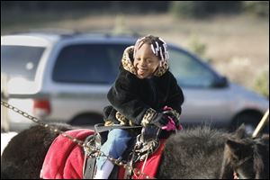NBRN matthes04p Aaniya (cq) Jordan, 3, of Detroit, on a pony from Lynda's (cq) Pony Rides.  25th annual Christmas tree festival at Matthes Evergreen Farm in Ida, Michigan, on November 29, 2008.  The Blade/Jetta Fraser