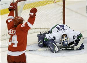 The Red Wings' Derek Meech celebrates scoring a third period goal as Canucks goalie Curtis Sanford reacts Thursday night.