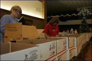 Sharron Pinkley, left, and Cheryl Thompson help get 400 boxes ready for shipment.
