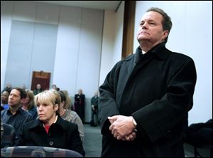 Developer Brian McMahon, right, listens as Mr. Finkbeiner defends his service. The mayor also accused Mr. McMahon and other Take Back Toledo backers of ethical misdeeds.