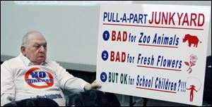 Daniel Kazmierczak makes his opinions known on a sign opposing the planned salvage operation in his neighborhood in South Toledo. The meeting turned contentious at times. 