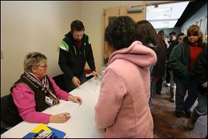 Jeanette Hrovatich of the United Way and Don Schiewer of Food for Thought register individuals for the food-mobile s recent visit to South Toledo s Aurora Gonzalez Community Center.