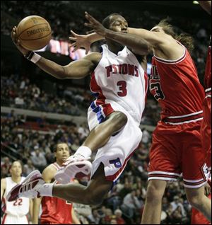 The Piston's Rodney Stuckey makes a pass around the Bulls' Joakim Noah last night at the Palace.