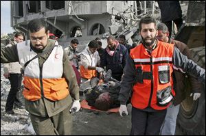 Palestinian medics carry the body of a security force officer from Hamas after an Israeli missile strike at the former headquarters of Palestinian President Mahmoud Abbas in Gaza City on Saturday.