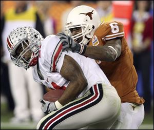 Ohio State cornerback Anderson Russell intercepts a pass intended for Texas wide receiver Quan Cosby in the first half.