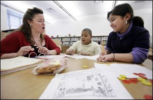 Kimberly Schroeder, a kindergarten teacher at Sherman Elementary, helps Anthony Lemons, 9, and Natalie Landaverde, 9, with a language arts assignment. The 9-year-olds were among 30 to 40 students getting homework aid. 