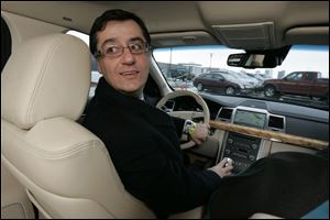 In a 2010 Lincoln MKS, Ali Jammaol, an engineer with Ford Motor Co., demonstrates the vehicle's self-parking function he helped design. Its steering system uses an electric motor rather than hydraulics. 