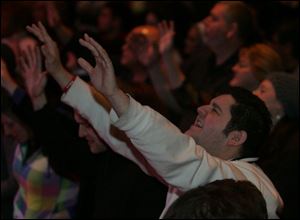Marty Self of Holland lifts his hands in prayer during the opening of the Holy Toledo Day of Prayer at the Valentine Theatre.

