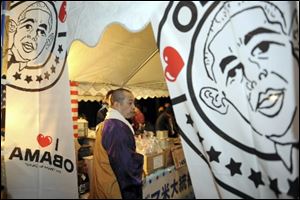 Chief priest Shoryu Tamagawa with the Haga-ji temple visits a tent decorated with portraits of President Obama as this northern Japan city of Obama celebrates the inauguration Tuesday.