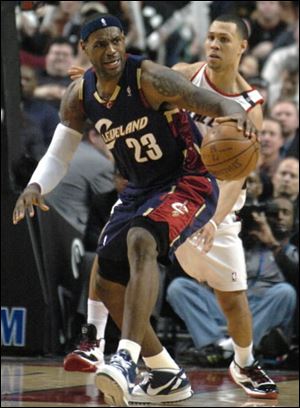 The Cavaliers' LeBron James is defended by the Trail Blazers' Brandon Roy last night in Portland, Ore James had 34 points as the Cavaliers beat the Trail Blazers 104-98.