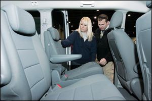 Amy and Brett Bethel examine a Dodge Grand Caravan SE at the Toledo Auto Show. The Bethels, who have two young children, are looking into the prospect of getting a larger vehicle soon.