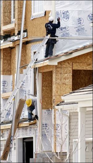 Builders work on a home in a new development in northeast Denver in April. The Commerce Department reported yesterday that new home construction plunged to an all-time low since recordkeeping began in the 1950s: 33 percent over the last year. In the Toledo area, it tumbled 53 percent in Bedford Township and more than a third in the Toledo area.