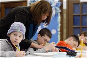 Alexa Brown, left, of Clyde, Ohio, participates in an art class at Green Springs School. The 10-year-old was diagnosed with a brain tumor in 2006. The tumor was removed, but cancer reappeared in her spine in May.
