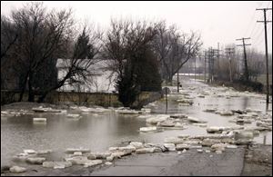 Water and ice from the River Raisin cover Winchester Street in Monroe. The river spilled its banks at Veterans Park as well.