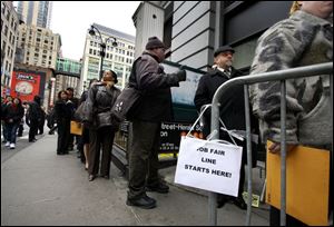 Job seekers stand in line at a job fair in midtown Manhattan. New jobless claims totaled a higher-than-expected 627,000 last week.