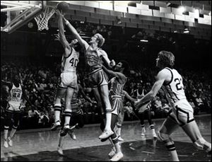 BGSU's Ron Hammye reaches over Toledo's Mike Larsen for a rebound in 1976. Hammye, a 1974 Genoa gradute, left BGSU
as the 11th all-time scorer and the fourth all-time rebounder.