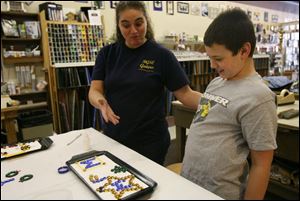 Slug:  CTY artclass23p                              Date 2/22/2009           The Blade/ Amy E. Voigt                     Location: Toledo, Ohio  CAPTION:  Amanda Fleming (cq one m), left, compliments her son Aaron Fleming, right, from Haskins, during Mom & Me: Nugget Madness at Prism GlassWorks, Ltd., which is designed for parents (or grandparents) to work alongside their children, using glass nuggets and  dots, to design and create ornaments, crosses, suncatchers, pendants and more.