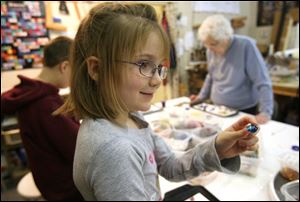 Slug:  CTY artclass23p                              Date 2/22/2009           The Blade/ Amy E. Voigt                     Location: Toledo, Ohio  CAPTION:  Brielle (cq) Heft,  from Haskins, shows her friend a particularly colorful piece of glass during Mom & Me: Nugget Madness at Prism GlassWorks, Ltd., which is designed for parents (or grandparents) to work alongside their children, using glass nuggets and  dots, to design and create ornaments, crosses, suncatchers, pendants and more.