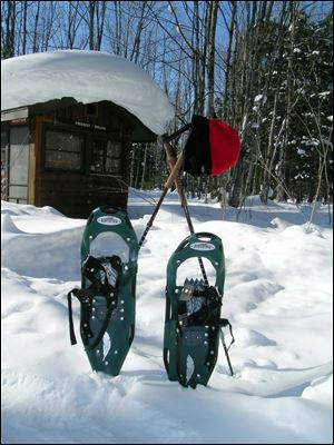 Snowshoes and trekking poles help hikers traverse  the woods in the Porkies.