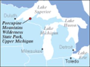 The Porcupine Mountains Wilderness State Park is Michigan s largest park.
 It was established in 1945 to protect the last uncut stands of northern hardwoods and eastern hemlock forest remaining in the Midwest.
The mountains here, reaching some 1,400 feet above mighty Lake Superior, stretch almost 2,000 feet above sea level, reaching 1,958 feet at Summit Peak, the high point in Michigan.
The Porkies  modern name derives from the Lake Superior Objiwa, who called them  Kaug Wudjoo,  or place of the crouching porcupine.
The park is just 20 acres shy of 90,000 and stretches 25 miles along the Superior shoreline.
It averages 10 miles deep, its southerly reaches abutting the Ottawa National Forest.
Nearly 48,000 acres of the park were designated as wilderness in 1994; motorized traffic is restricted to a few peripheral roads.
To reach its wild interior wonders, you go on foot except in winter, when snowshoes or cross-country skis are a must, particularly off well-used and well-packed Nordic trails.
 Snow can be five or six feet deep, more in drifts and ravines.
The Porkies lie in the western Upper Peninsula, some 300 miles west of the Michigan peninsulas  famed connector    the Mackinac Bridge.
 The mountains lie slightly north and 100 miles east of Duluth  and 200 miles northeast of Minneapolis-St.Paul.
 They are farther west than Madison, Wis., and lie on about the same longitude as the great easterly bend of the Mississippi River between Dubuque and Davenport, Iowa.
 They are 650 miles from Toledo, closer to Chicago than to Detroit, and part of Michigan s  spoils  after losing a southern border strip to Ohio in the infamous  Toledo War  in 1836.
  Steve Pollick