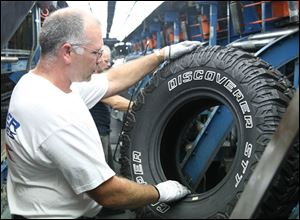 James Brown, Jr., does an inspection at Cooper Tire, a firm Standard & Poor s analysts say is  highly leveraged  with debt of $855 million. Company spokesmen say it is not in danger of bankruptcy.