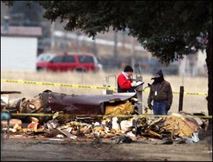 Officials investigate the scene of fatal plane crash outside the Butte Airport in Butte, Mont., on Sunday, March 22, 2009. A small plane, possibly carrying children on a ski trip, crashed Sunday as it approached the Butte airport, killing 14 to 17 people aboard, according to a federal official. The single engine turboprop nose-dived into a cemetery 500 feet (150 meters) from its destination. 

