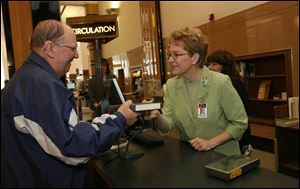 Slug: CTY marcy13p                                Date 4/13/2009           The Blade/ Amy E. Voigt                     Location: Toledo, Ohio  Caption: U.S. Rep. Marcy Kaptur (D., Toledo), center, checks out books for George Tucker, left, with the help of library employee Cathy Bartel, right, on April 13, 2009.  Kaptur spent one hour with librarians and clerks to assit patrons with checking out their  materials as part of the library's 