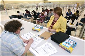 Kathy Snyder of Temperance, right, speaks with Christine Bickell with Savers about being hired at the company's Executive Parkway shop during the hiring fair, which drew hundreds. 