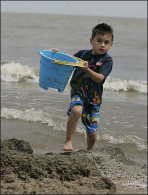 ROV moat water    04/27/2009     The Blade/Lori King  Dundee, Mich. Taylor Hernandez, 4, fills a bucket with Lake Erie water to fill his castle moat he and his uncle made at the Luna Pier beach. The family was enjoying an unusually warm but windy day along the lake.