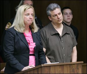 Michael Swiergosz, 46, stands with his lawyer, Jane Roman, during his arraignment in Toledo Municipal Court on charges related to Tuesday's hostage-taking at Sunset Retirement Communities.