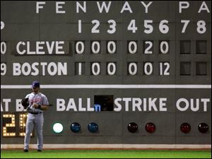 Cleveland Indians left fielder David Dellucci looks down at his glove during the sixth inning, in which the Boston Red Sox scored 12 runs.