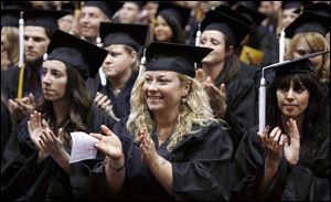 Slug: CTY OWENSGRAD08P C         The Blade/Jeremy Wadsworth  Date: 05/08/09  Caption: Heather Puhy of Maumee celebrates graduating with an Associate degree of Arts Friday, 05/08/09, at Owens Community College.