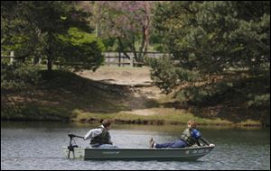 Slug: CTY olander11p         The Blade/Jeremy Wadsworth  Date: 05/10/09  Caption: Left Jacob Holloway, 12, of Sylvania, and Colton Snider, 13, of Sylvania ride a boat around  Lake Olander Sunday, 05/10/09, during the 