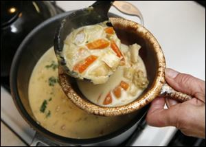 LeAnn Hall fi lls a bowl with Waterzooi.