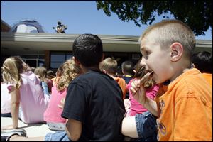 Zachary Miller, 5, eats an ice-cream treat while listening to the reading.
