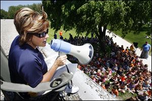 Deb McCain, principal of Mason Consolidated Elementary School, reads a book to students from the school s roof to settle a bet she made with them if they exceeded a monthly challenge for the accelerated reading program. She agreed to camp out overnight on top of the school if the students surpassed the reading goal. The theme of the challenge   fittingly   was  Camp out with a good book. 