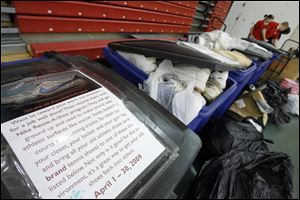 Bins full of shoes are lined up before being shipped in the Nike Reuse-A-Shoe program. The shoes will be ground and used to make athletic surfaces such as soccer fields, basketball courts, and running tracks.