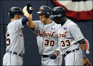 Magglio Ordonez, center, is met by Ryan Raburn, left, and Marcus Thames after his three-run home run, but it wasn't enough.