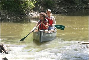 Emily Ziegler and Tim Schetter prepare to deal with some shallow water during Monday's trip by 16 environmentalists.