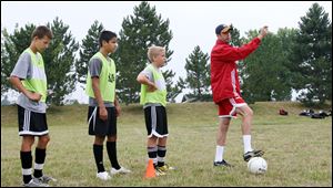 Mark Delaney, right, a former fullback for Aston Villa of the
English Premier League, instructs campers at Pacesetter Park.