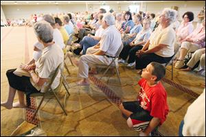 Noah Roscoe, 9, foreground, listens to speeches at the Masjid Saad mosque during one of the  summer tours.