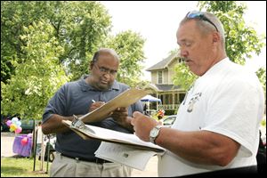 Toledoan Don Gozdowski, right, missed the required number of valid signatures to qualify for the September primary election in Toledo. The man signing last month did not want to be identified.