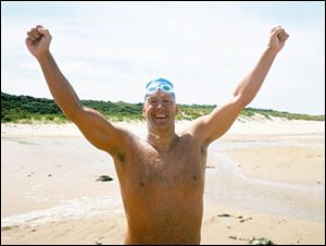 John Muenzer celebrates crossing the English Channel after he reached his destination in France. Muenzer set six schoolrecords when he was a swimmer at the University of Toledo.