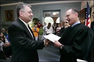 the blade/lori king Jose Carlos Porcello Da Silva received his citizenship papers from U.S. District Judge Jack Zouhary during Friday's naturalization ceremony in the Manor House at Wildwood Metropark.