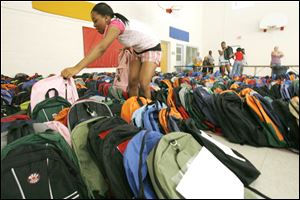 Slug: REL BACKPACKS20p          Date 8/20/2009           The Blade/ Amy E. Voigt           Location: Toledo, Ohio  CAPTION:  Jasmine King, an employee at The Salvation Army, picks through hundreds of new backpacks to choose a pink one for a client while handing out  hundreds of backpacks and other school supplies on August 20, 2009.
